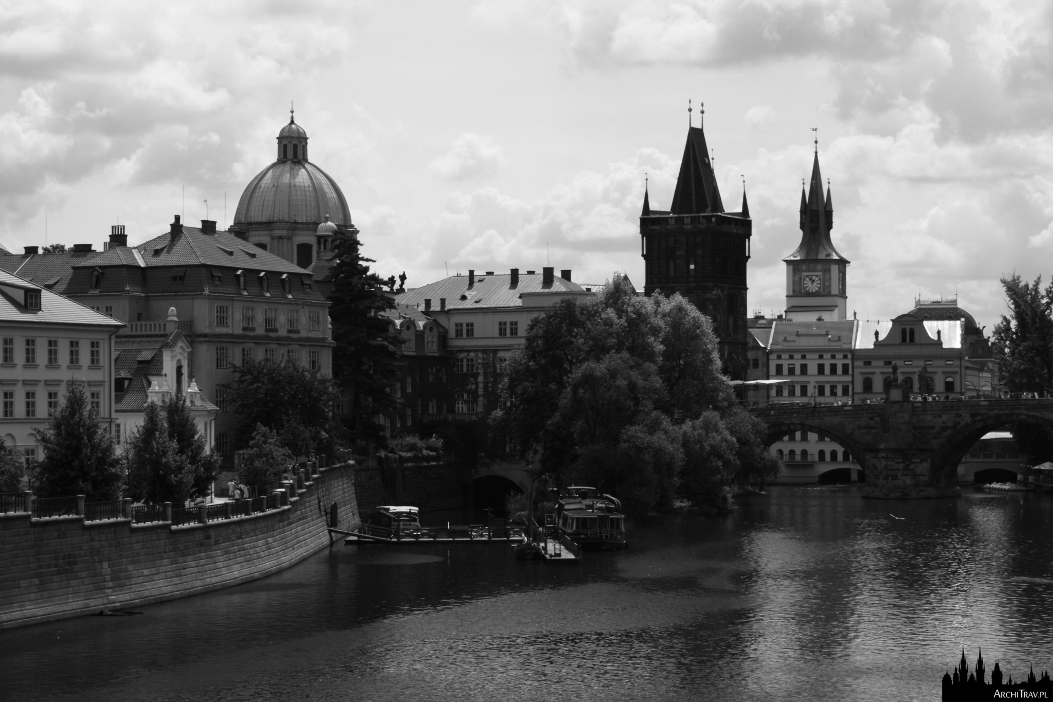 czarno białe zdjęcie prawego brzegu Wełtawy, widok na Wieżę Staromiejską i po prawej Most Karola