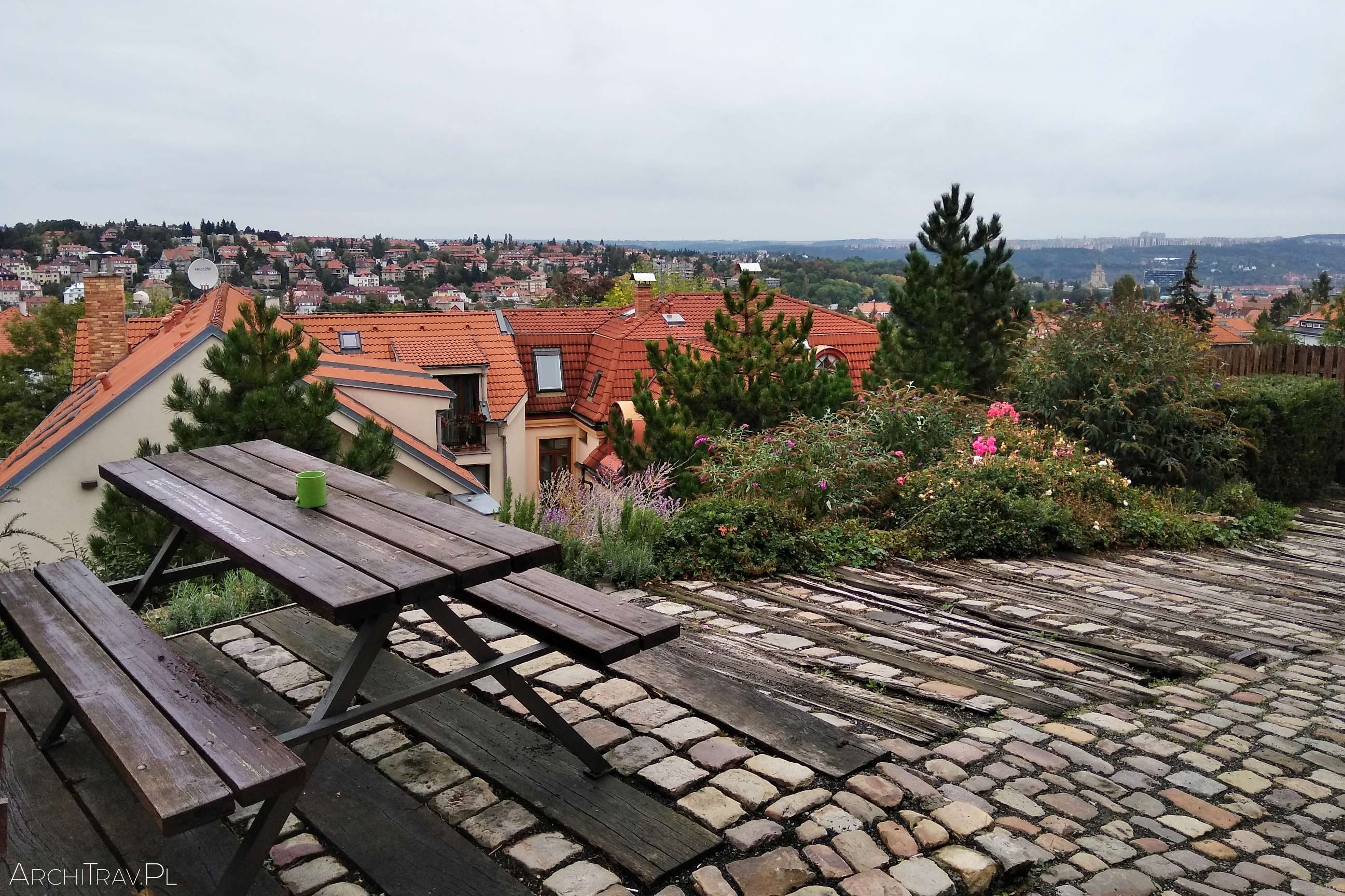 widok na Pragę z góry, na pierwszym planie ławeczki ze stołem